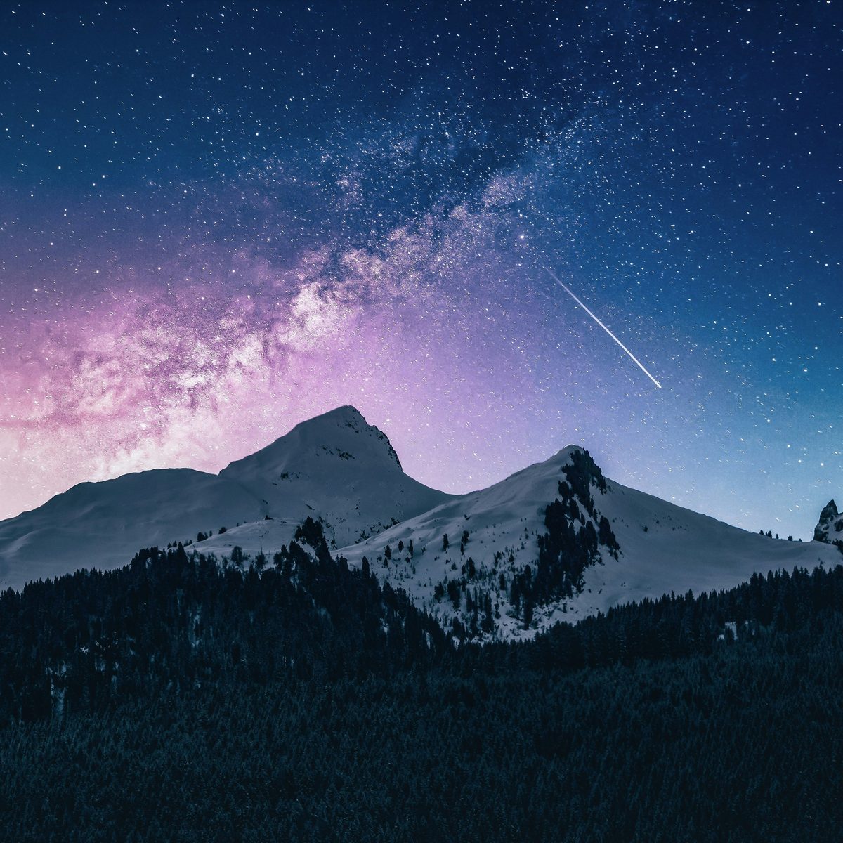 Starry night sky above mountain peaks at a campground